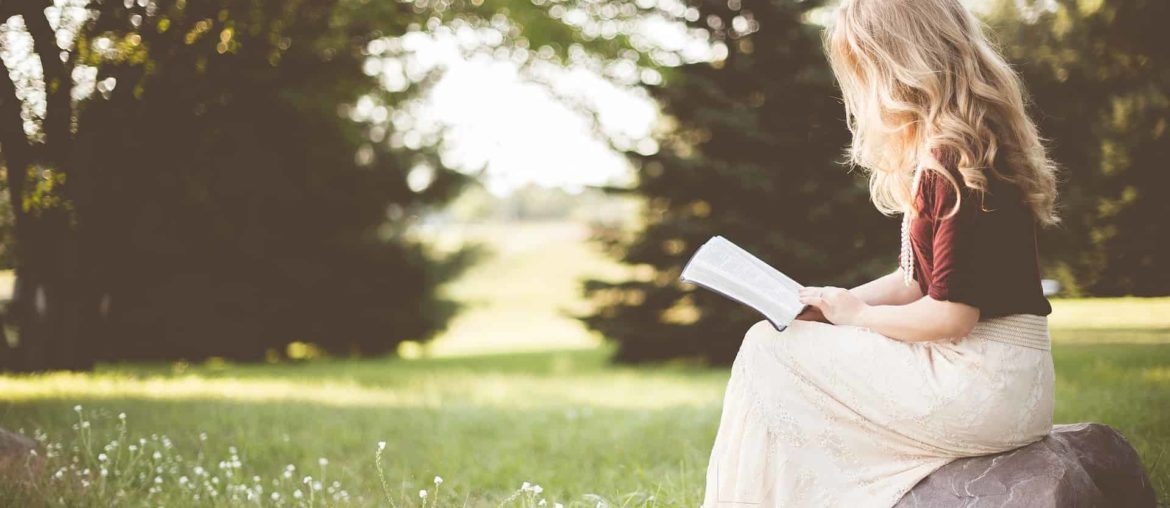 Lady reading a book in the sunshine