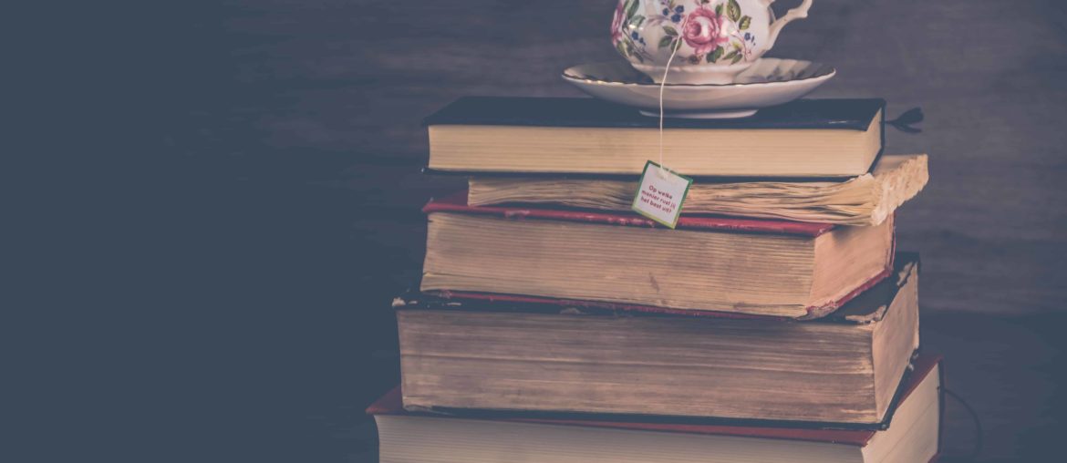 Cup of tea resting on old books