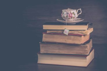 Cup of tea resting on old books