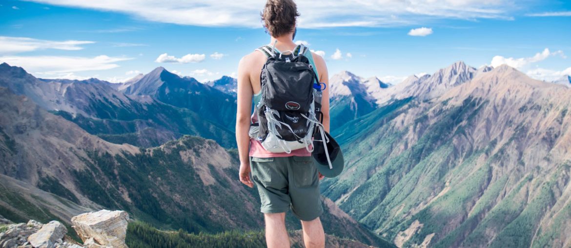 hiker standing on top of mountain