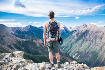 hiker standing on top of mountain