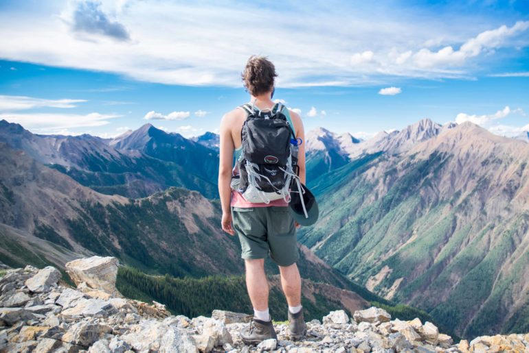 hiker standing on top of mountain
