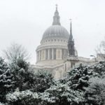 dome of st pauls above snow-covered trees in london