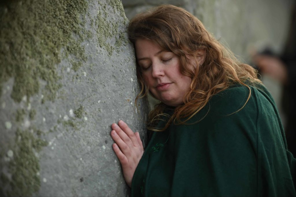 hippy hugging a rock at stonehenge