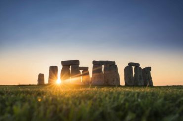 view of stonehenge at sunset from the mound