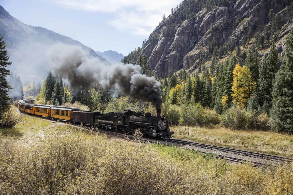 locomotive steam engine passing through mountain pass