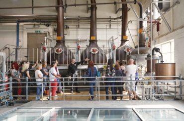 tour group next to copper stills at the beefeater gin distillery tour in london