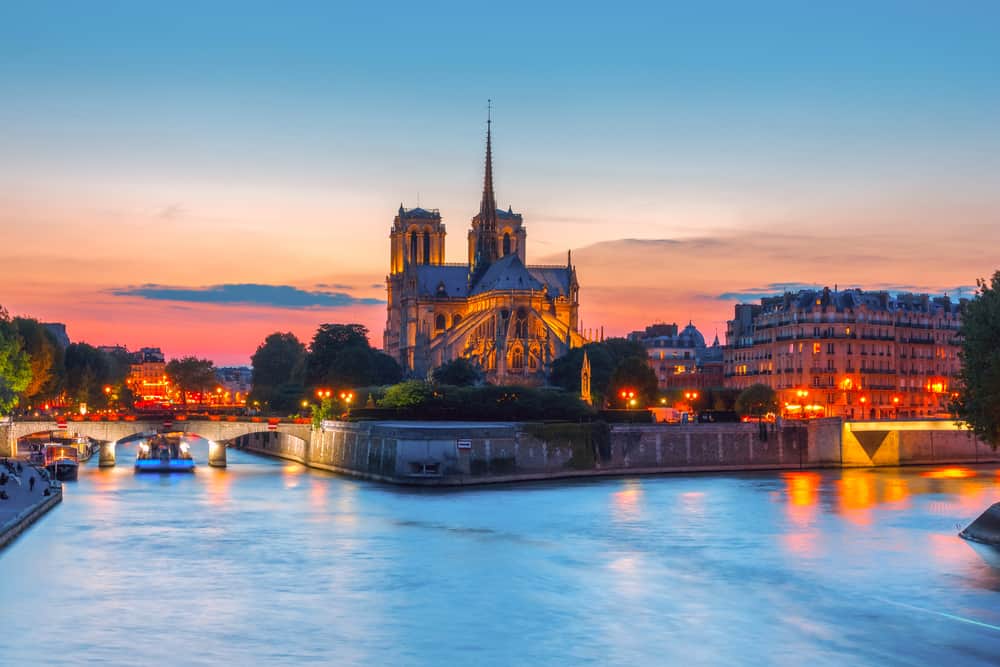 cruise boat in the river seine in paris next to notre dame cathedral