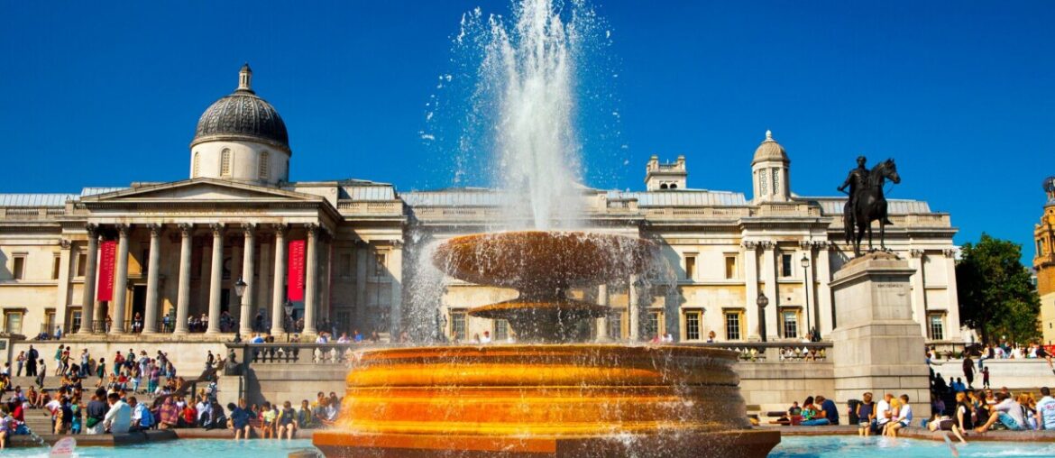 photo of the national gallery in trafalgar square with a fountain in the center