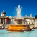 photo of the national gallery in trafalgar square with a fountain in the center